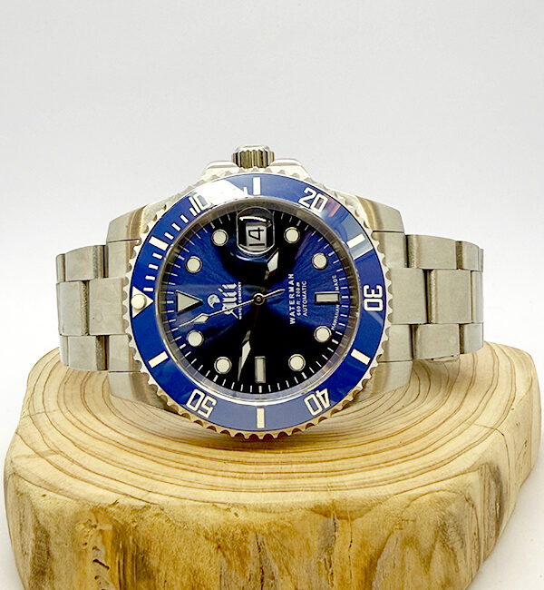 Ali'i Watch Company Waterman watch with a blue dial and bezel sits on a piece of wood.