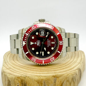 Ali'i Watch Company Waterman watch with a red dial and bezel sits on a piece of wood.
