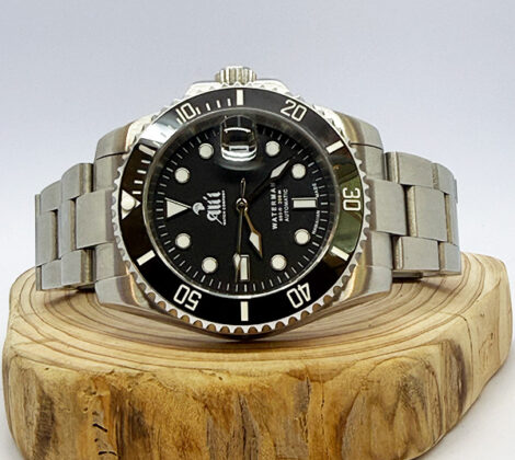 Ali'i Watch Company Waterman dive watch with a black dial and bezel sits on a piece of wood.
