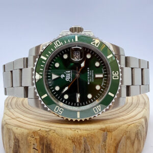 Ali'i Watch Company Waterman watch with a green dial and bezel sits on a piece of wood.