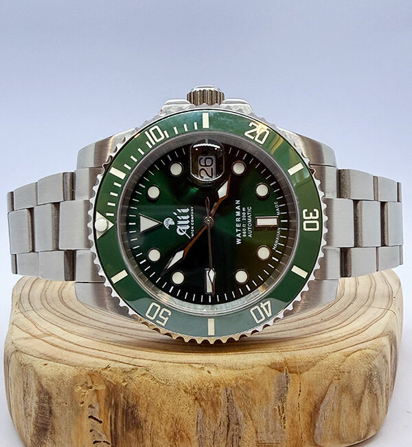 Ali'i Watch Company Waterman watch with a green dial and bezel sits on a piece of wood.