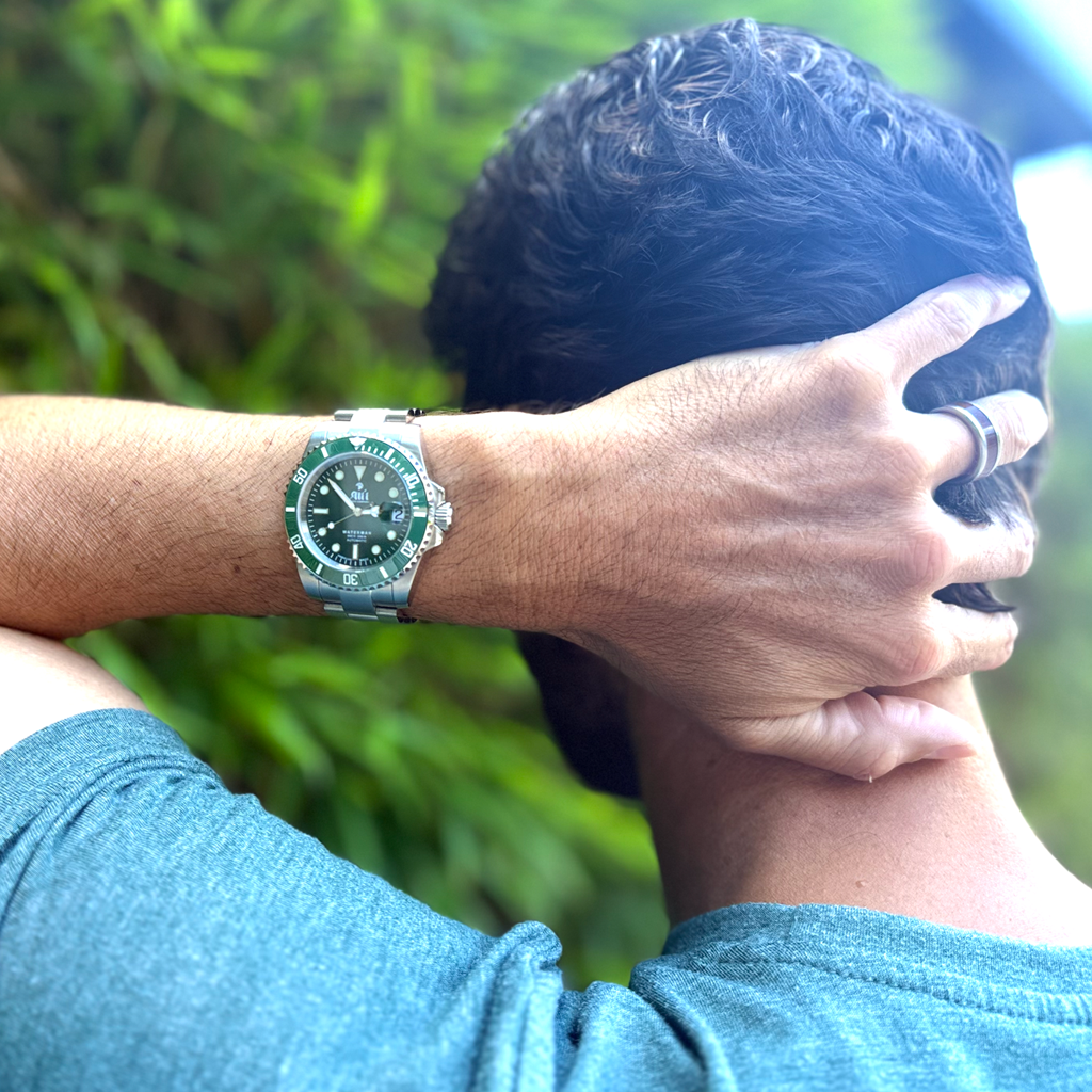 Ali'i Watch Company Waterman Green on a man's wrist in front of bamboo.