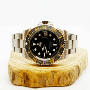 Ali'i Watch Company Waterman watch with a black bezel and carbon fiber bezel with yellow minute markers sits on a piece of wood.