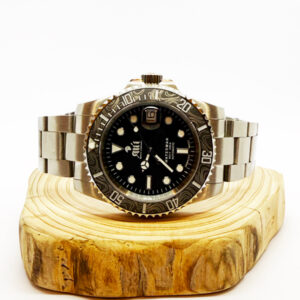 Ali'i Watch Company Waterman watch with a black bezel and carbon fiber bezel with silver minute markers sits on a piece of wood.