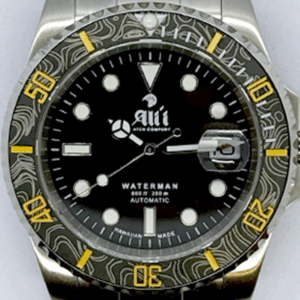 A close up of the dial on the Ali'i Watch Company Waterman watch with black dial and black carbon fiber bezel with yellow minute markers.