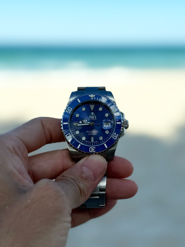 Ali'i Watch Company Waterman with a blue bezel and blue dial with the sand and ocean in the background