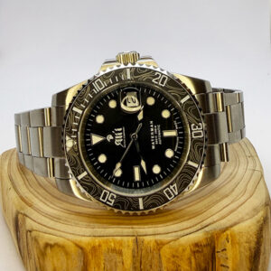 Ali'i Watch Company Waterman watch with a black bezel and carbon fiber bezel with silver minute markers sits on a piece of wood.