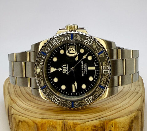 Ali'i Watch Company Waterman watch with a black bezel and carbon fiber bezel with blue minute markers sits on a piece of wood.