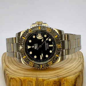 Ali'i Watch Company Waterman watch with a black bezel and carbon fiber bezel with yellow minute markers sits on a piece of wood.