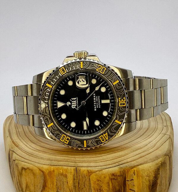 Ali'i Watch Company Waterman watch with a black bezel and carbon fiber bezel with yellow minute markers sits on a piece of wood.